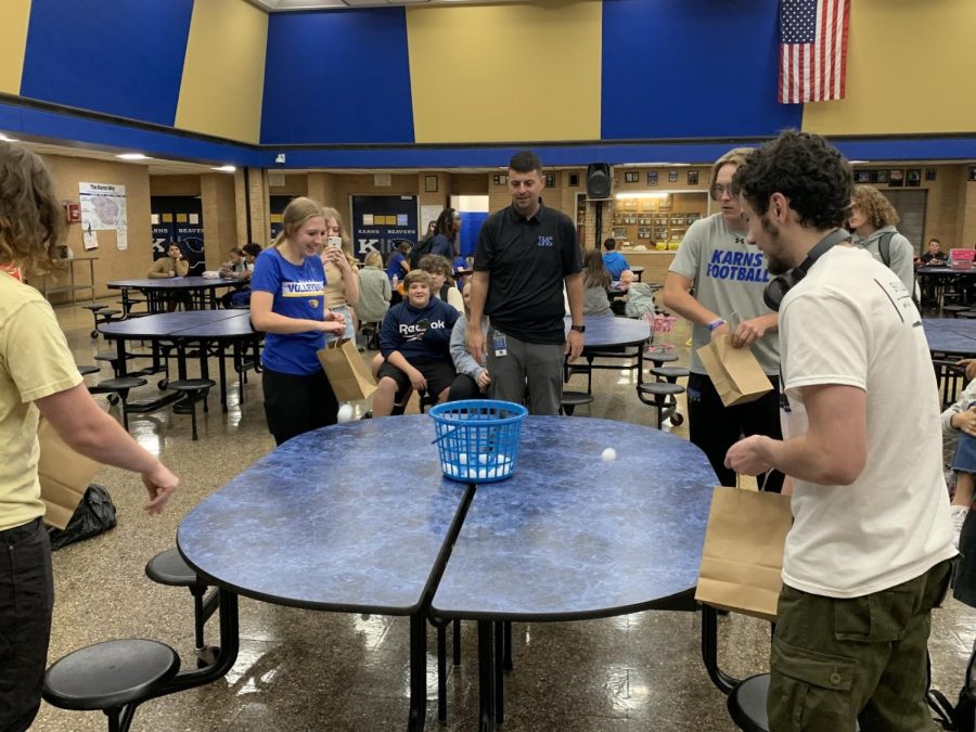 Students participate in a ping-pong toss as Mr. Collins looks on