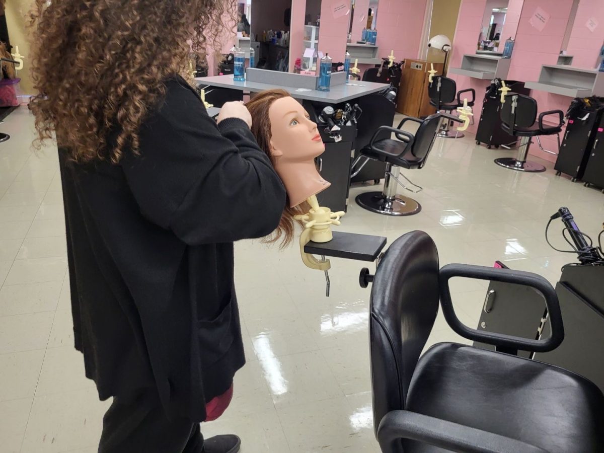 Jaidyn Phillips brushes the hair of a mannequin in her cosmetology class at Byington-Solway. 