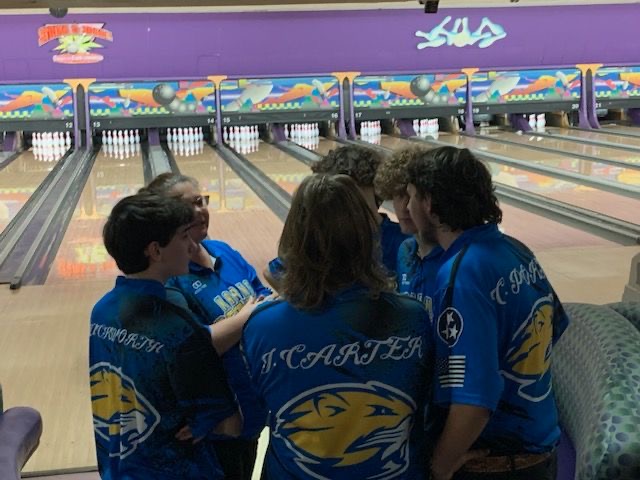 The Karns High Bowling Team huddles together during a break between frames at Strike and Spare. 