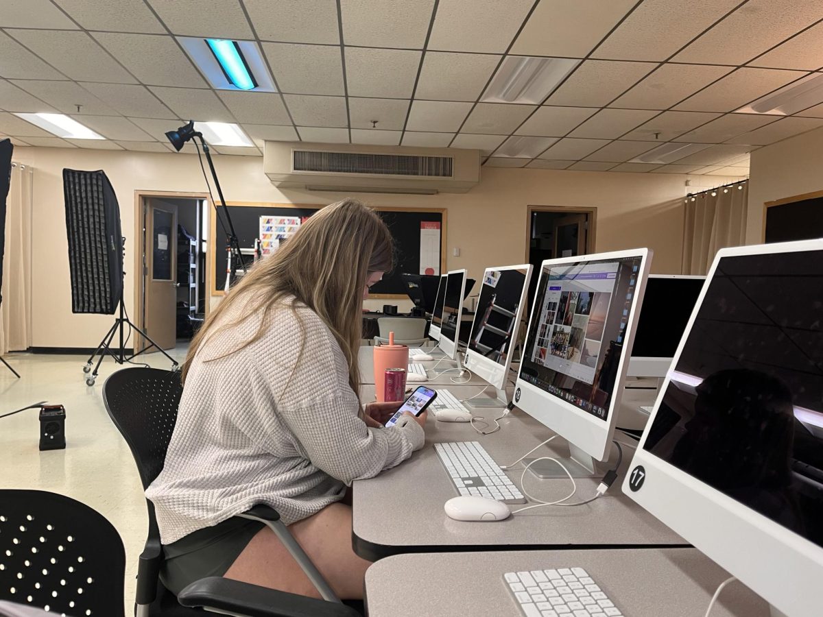 Ashley Dodge checks her text messages before class begins.